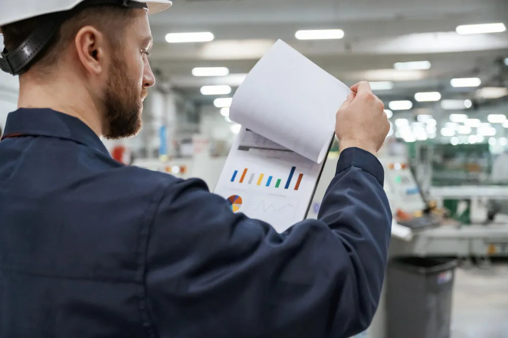 Engenheiro analisando relatórios de desempenho e não conformidades para aplicação do sistema CAPA em processos industriais.
