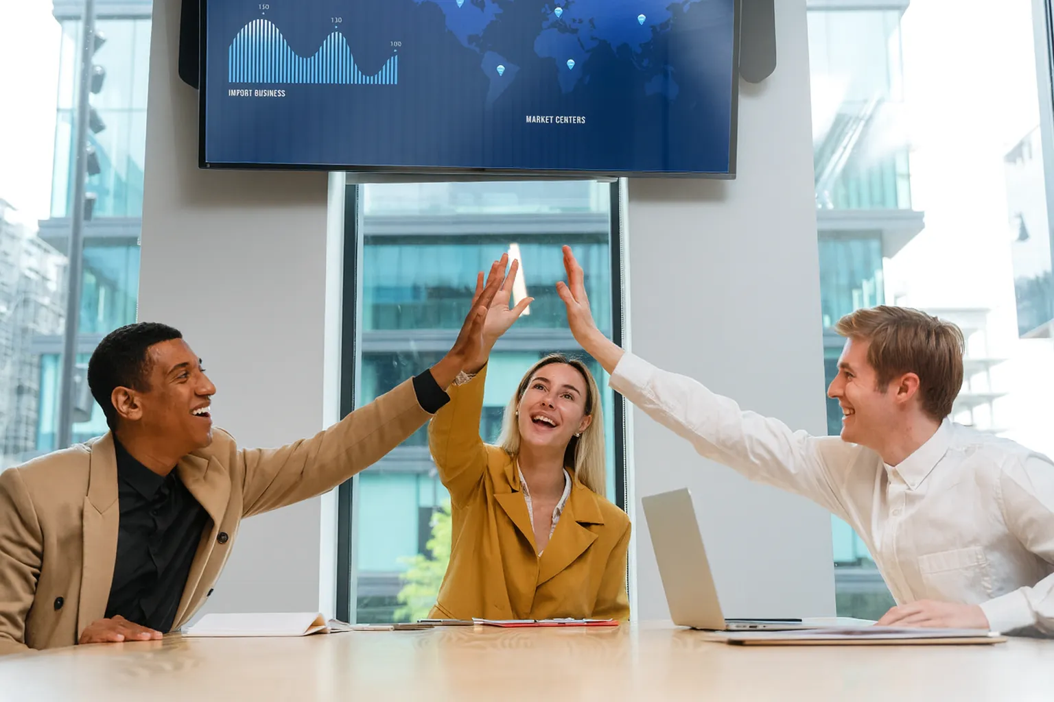 Profissionais celebrando o sucesso de um projeto após superar desafios de mudança organizacional, representando a aplicação da curva de Kübler-Ross na gestão da resistência à mudança.