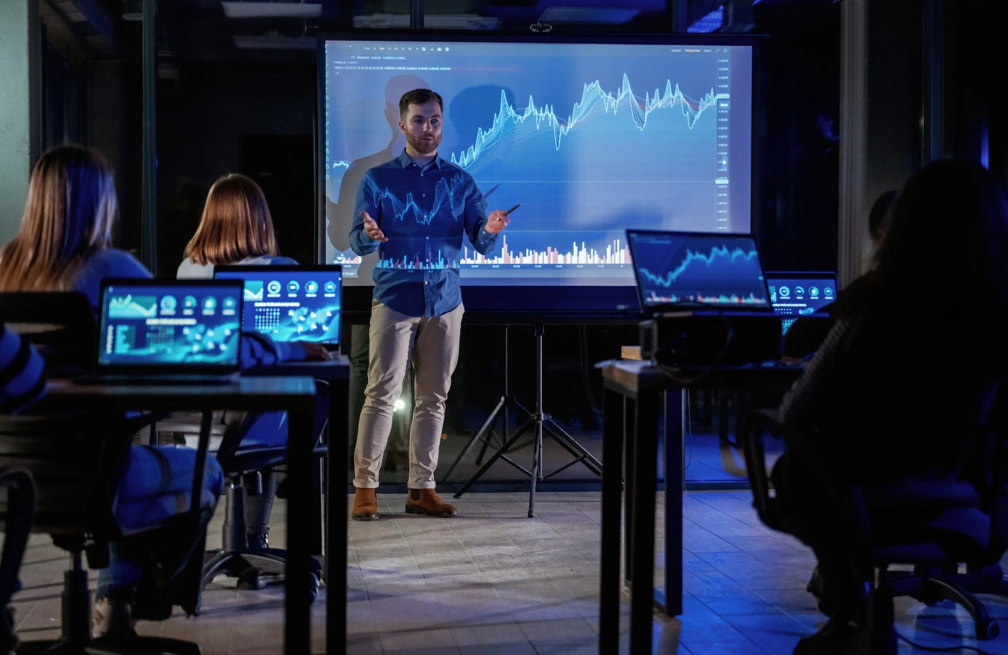 Instrutor apresenta gráficos de desempenho e inovação digital em uma sala de treinamento, representando o curso Liderança e Indústria 4.0: Transformação e Inovação.