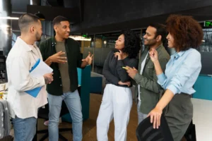 Grupo de profissionais conversando em ambiente corporativo, representando práticas de comunicação eficaz entre líderes e equipes.