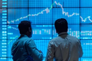 Profissionais observando gráficos de desempenho financeiro em tela digital, representando a análise de EBIT e EBITDA.