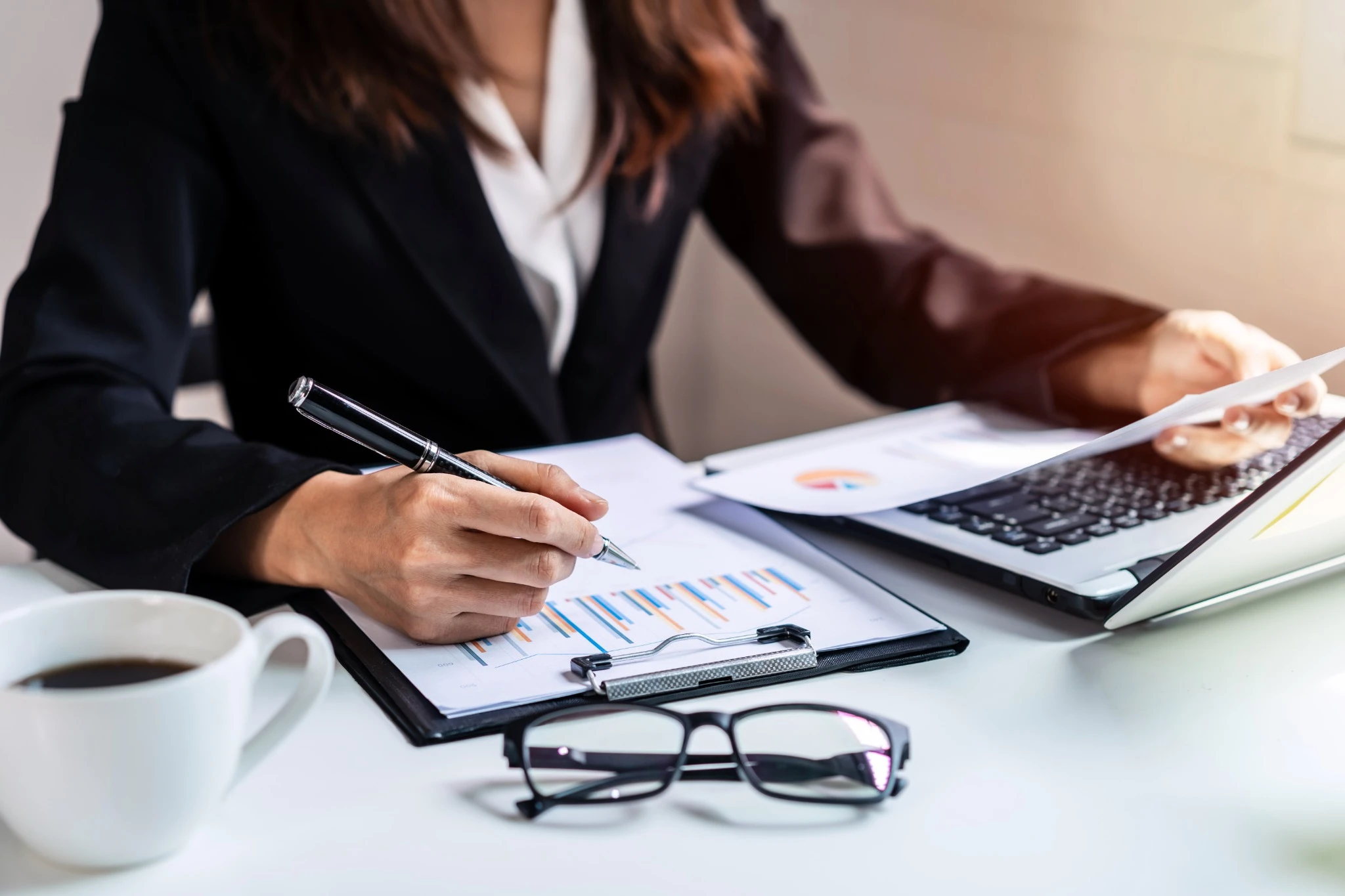 Profissional analisando gráficos financeiros no escritório, representando práticas essenciais de gestão financeira empresarial.