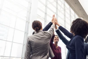 Equipe corporativa celebrando união e desempenho colaborativo em ambiente de trabalho