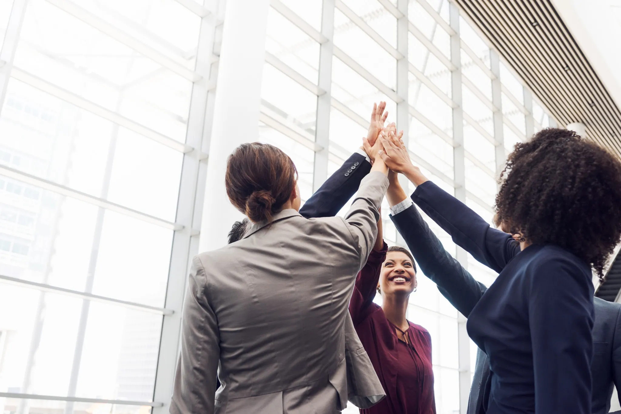 Equipe corporativa celebrando união e desempenho colaborativo em ambiente de trabalho