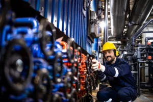 Técnico ajustando válvulas em sistema industrial durante atividade de manutenção preventiva