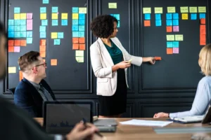 Profissionais discutindo um processo com post-its em um quadro de planejamento