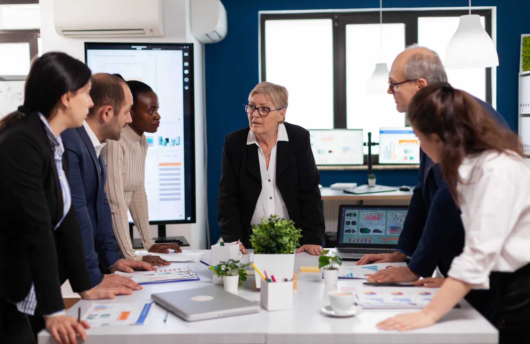 Equipe analisando indicadores e discutindo ações táticas em reunião de S&OE para garantir execução alinhada ao planejamento