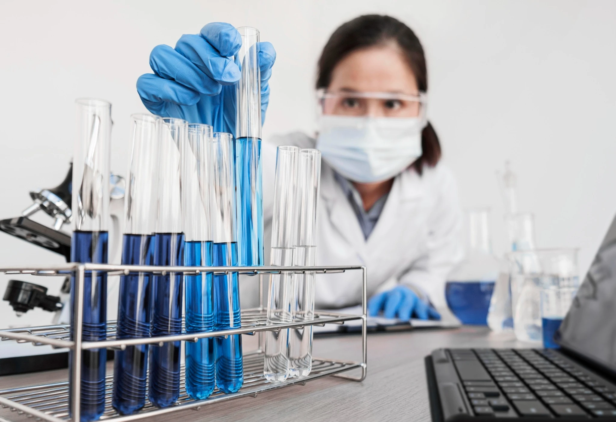 Cientista realizando análises laboratoriais com tubos de ensaio em validação de procedimentos analíticos segundo o ICH Q2(R2)